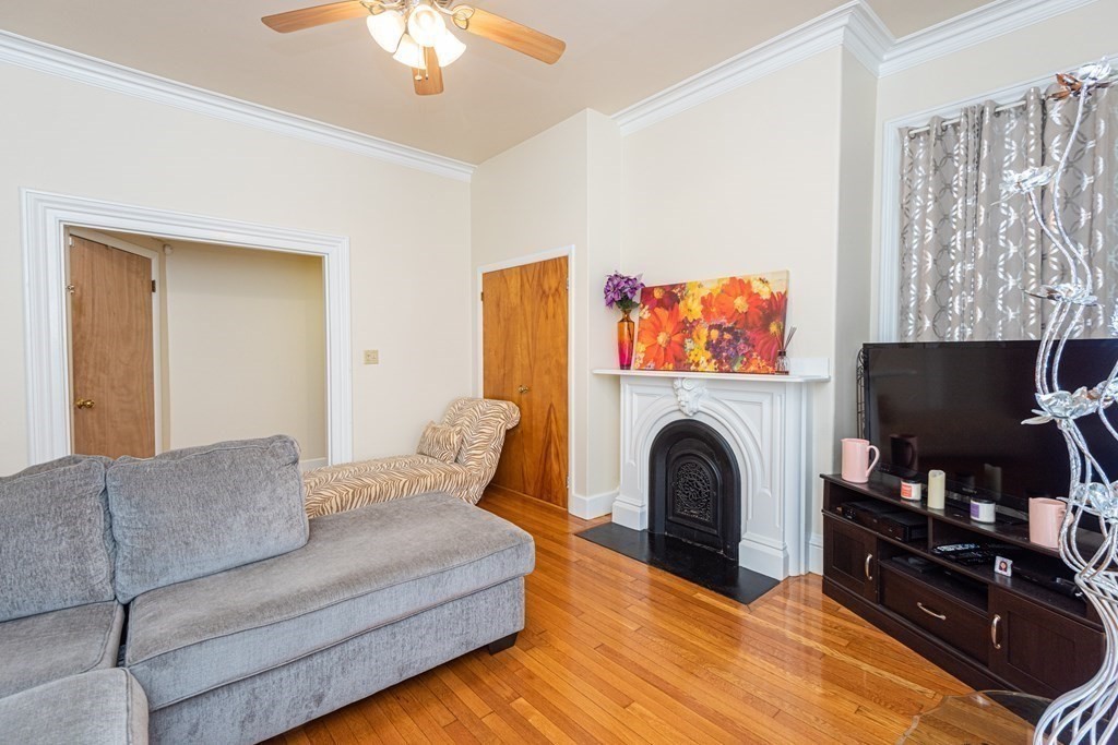 30 Chestnut Street Stoneham, MA 02180 - Photo 15 of 41 a living room with furniture a fireplace and a flat screen tv