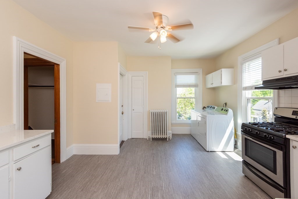 30 Chestnut Street Stoneham, MA 02180 - Photo 25 of 41 a kitchen with white cabinets and wooden floor