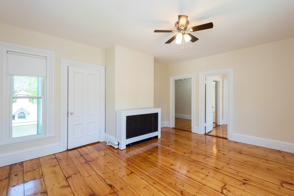 30 Chestnut Street Stoneham, MA 02180 - Photo 30 of 41 a view of an empty room with wooden floor and a ceiling fan