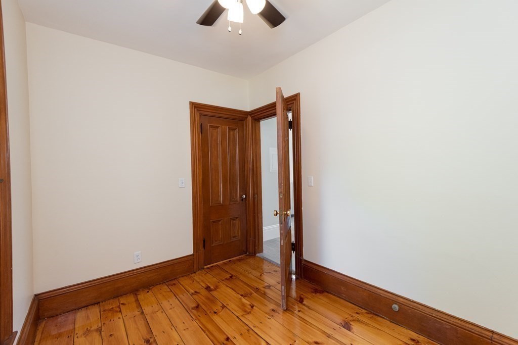 30 Chestnut Street Stoneham, MA 02180 - Photo 38 of 41 an empty room with wooden floor chandelier fan and closet