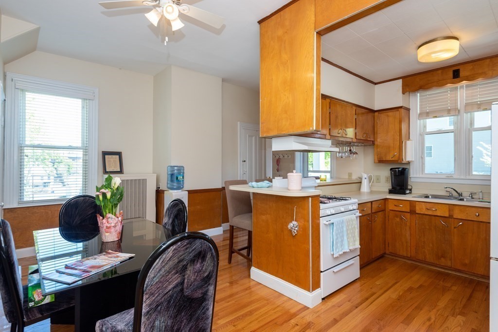30 Chestnut Street Stoneham, MA 02180 - Photo 10 of 41 a view of a kitchen with kitchen island granite countertop a sink cabinets and dining table
