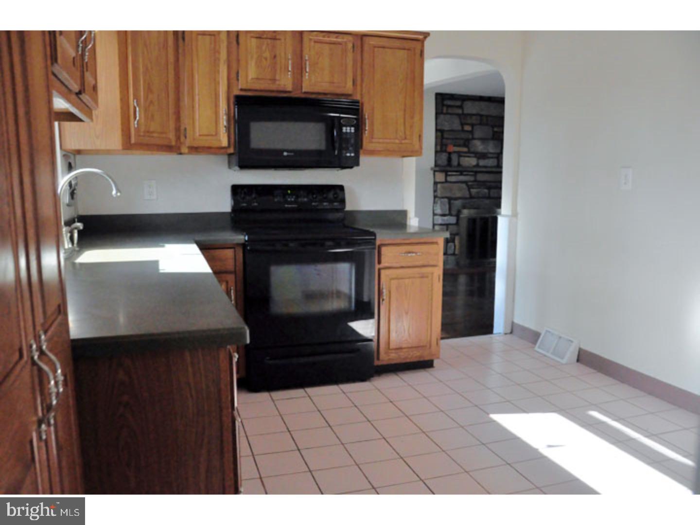 591 Farnum Road Media, PA 19063 - Photo 10 of 21 a kitchen with granite countertop a stove a microwave a sink and cabinets