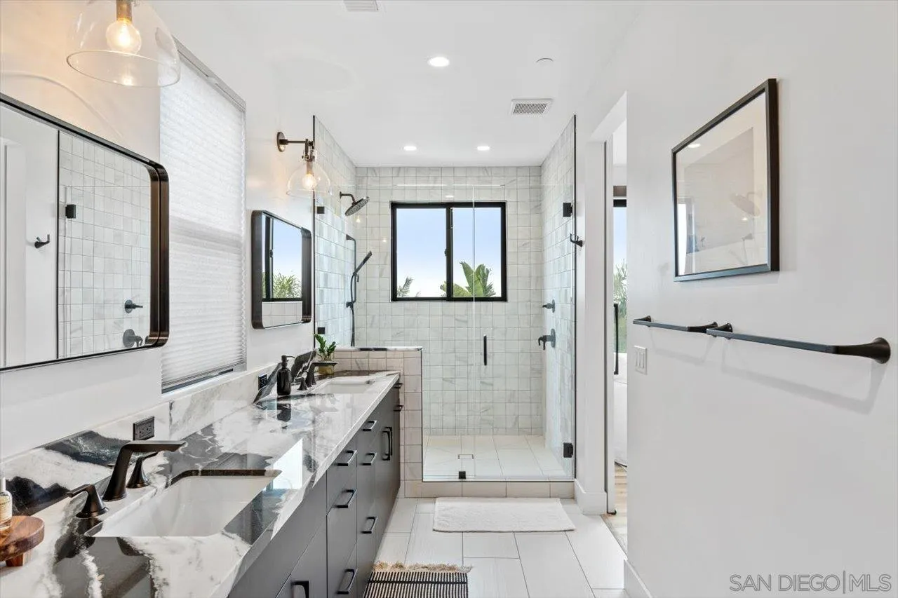 1604 Legaye Drive Encinitas, CA 92007 - Photo 14 of 43 a bathroom with double vanity sinks a mirror and a shower
