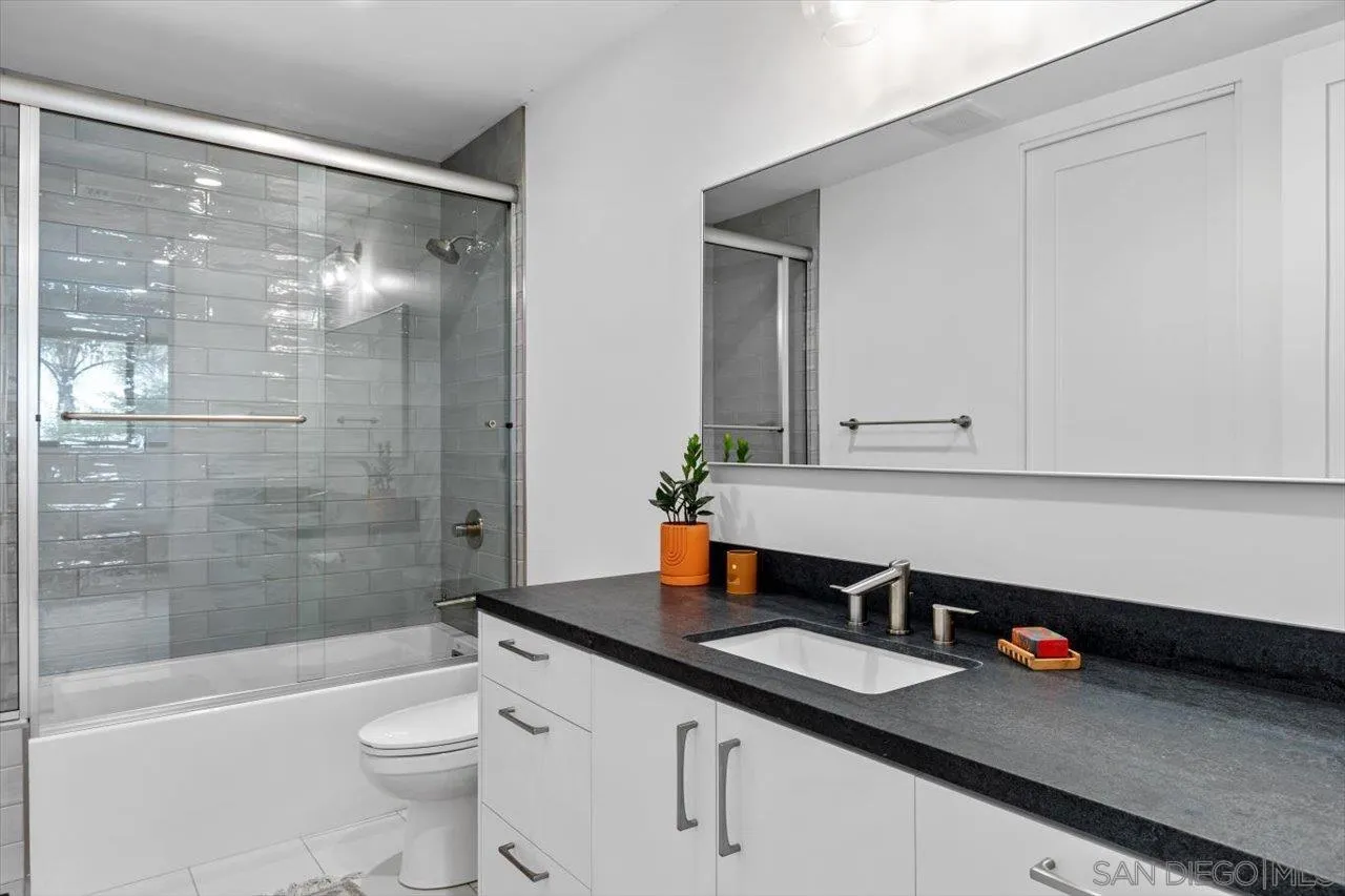 1604 Legaye Drive Encinitas, CA 92007 - Photo 33 of 43 a bathroom with a granite countertop sink a toilet and shower