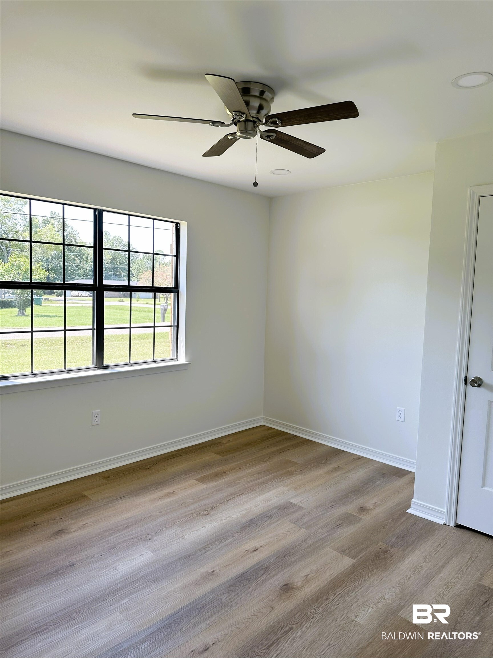 701 McRae Street Atmore, AL 36502 - Photo 6 of 11 Empty room with light wood-style flooring and a ceiling fan