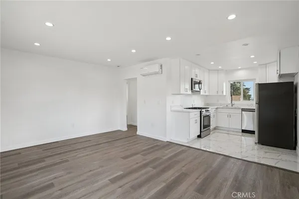 a view of kitchen with stainless steel appliances refrigerator stove microwave and cabinets