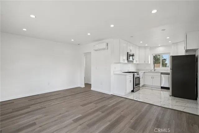 a view of kitchen with stainless steel appliances refrigerator stove microwave and cabinets