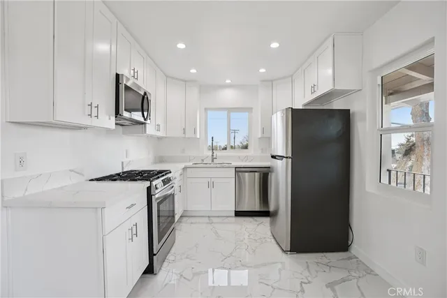 a kitchen with a sink a refrigerator and a oven