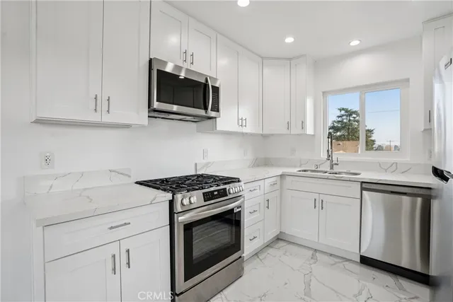 a kitchen with white cabinets and stainless steel appliances