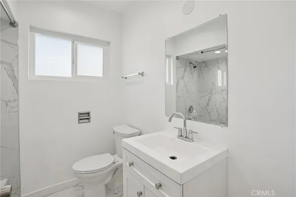 a bathroom with a sink toilet and a mirror
