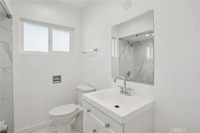 a bathroom with a sink toilet and a mirror
