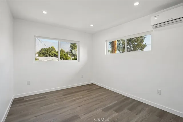 an empty room with wooden floor and window
