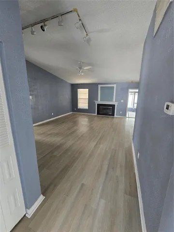 a view of empty room with wooden floor and fireplace