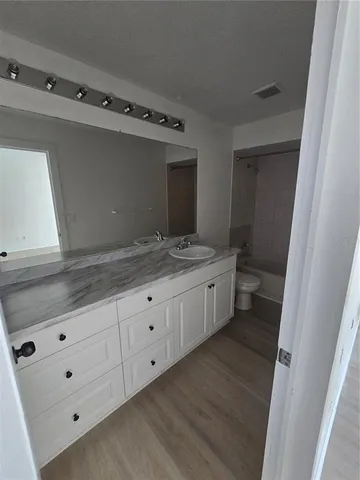 a bathroom with a granite countertop sink mirror and toilet