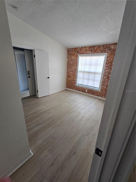 12825 Tallowood Drive Riverview, FL 33579 - Photo 7 of 10 a view of an empty room with wooden floor and a window