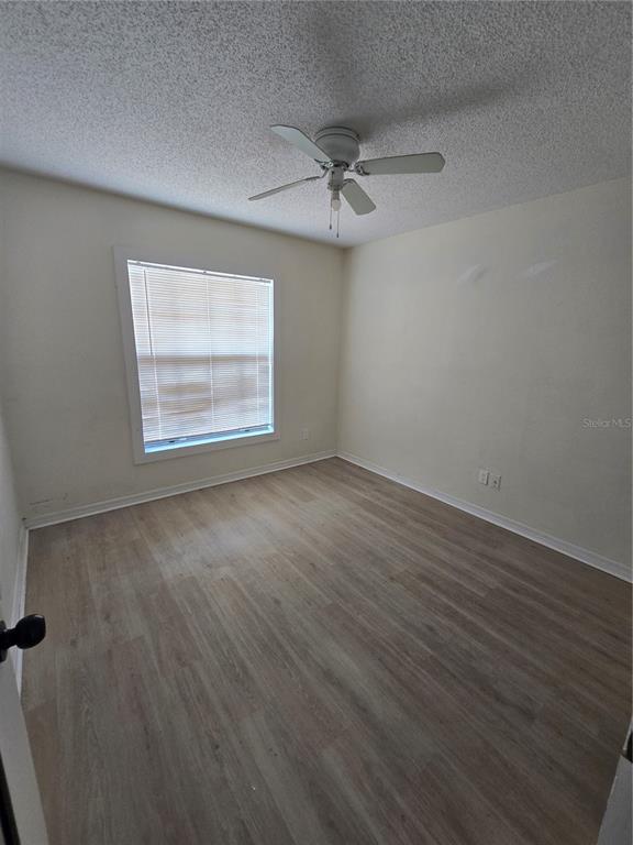 12825 Tallowood Drive Riverview, FL 33579 - Photo 8 of 10 an empty room with wooden floor windows and fan