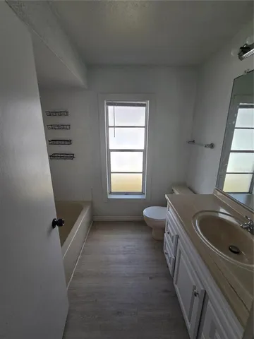 a bathroom with a sink a toilet and a window