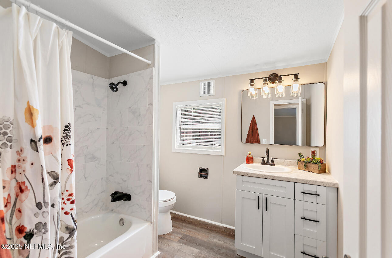 86090 Jean Road Yulee, FL 32097 - Photo 12 of 22 a bathroom with a double vanity sink toilet mirror and bathtub