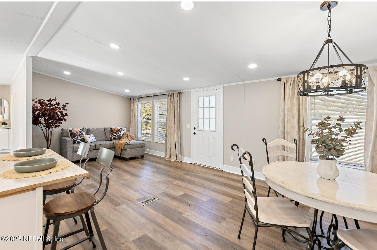 86090 Jean Road Yulee, FL 32097 - Photo 4 of 22 a living room with furniture a chandelier and a dining table
