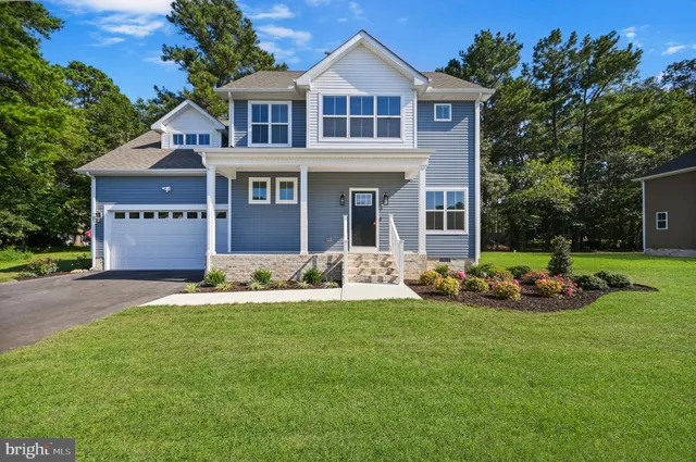 a front view of a house with a garden and yard