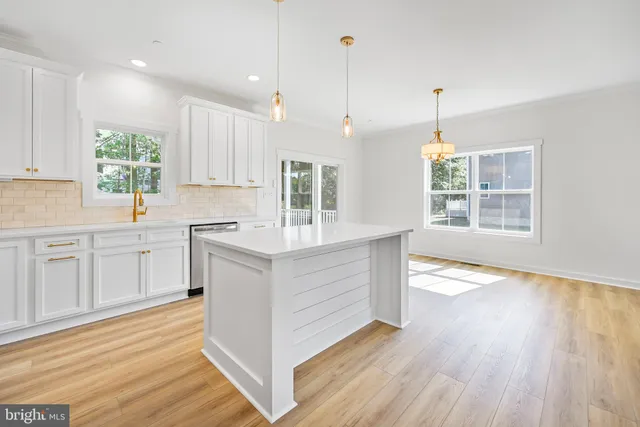 a kitchen with wooden floors and white cabinets