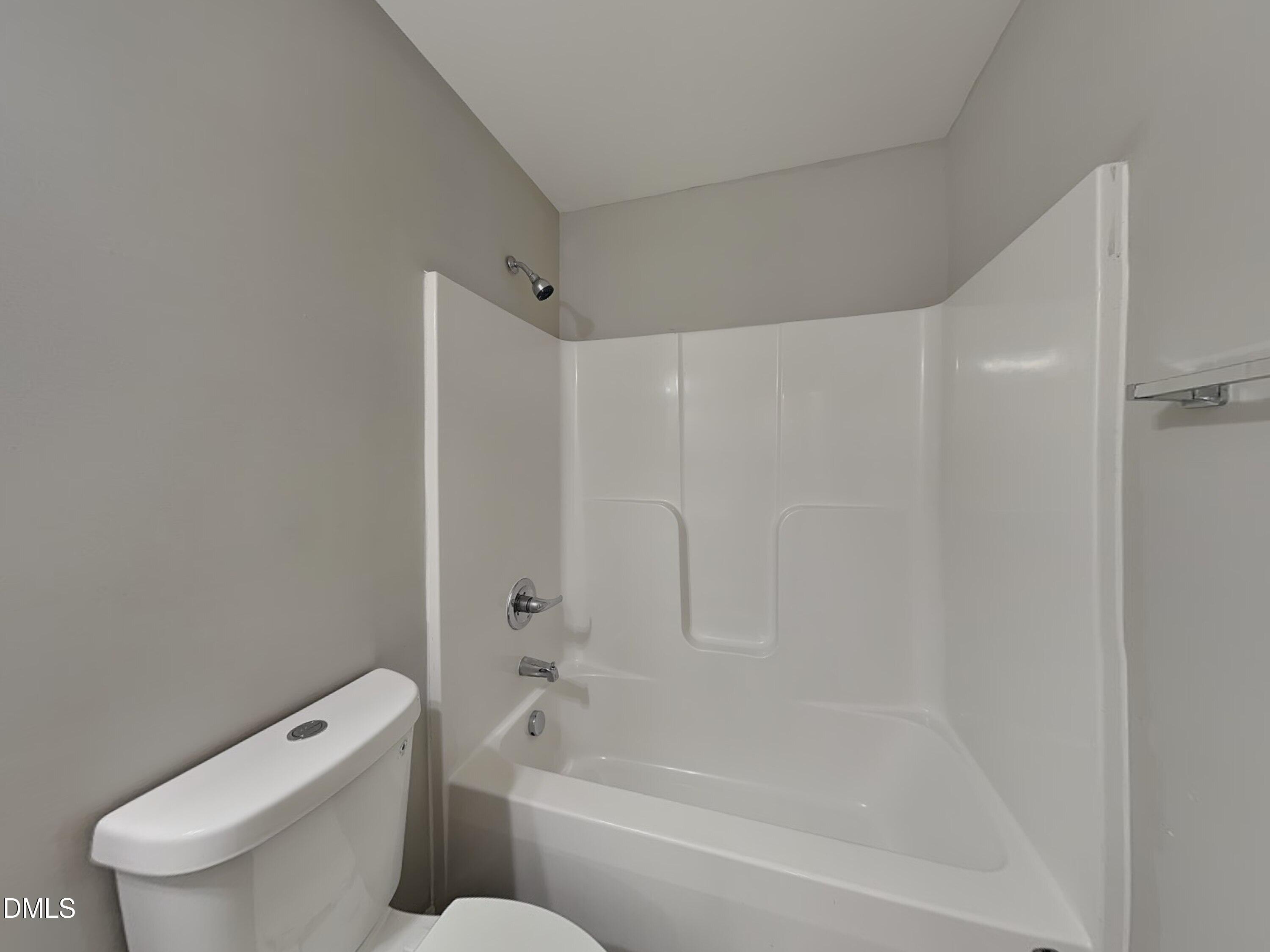 147 Cattail Lane Zebulon, NC 27597 - Photo 13 of 15 a white bath tub sitting next to a white toilet and a shower