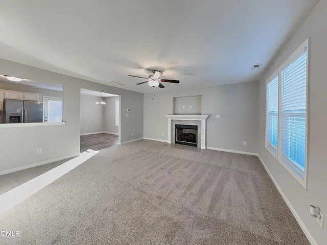 a view of an empty room with a fireplace and a window