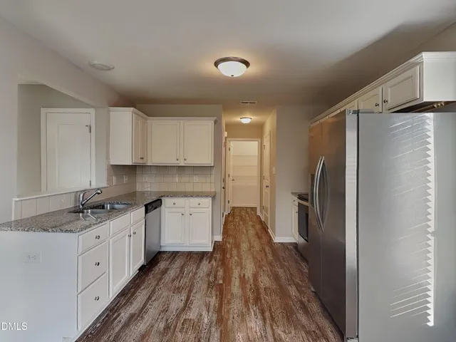 a kitchen with a refrigerator and a sink
