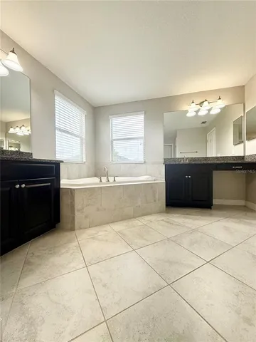 a large bathroom with a tub a sink and a mirror