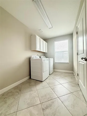 a utility room with cabinets washer and dryer