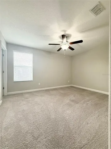 a view of an empty room with a ceiling fan