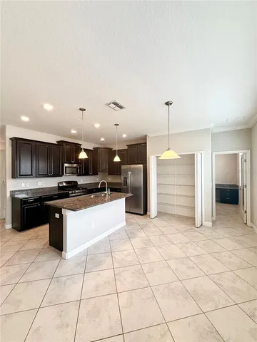 a large kitchen with stainless steel appliances kitchen island granite countertop a sink and cabinets