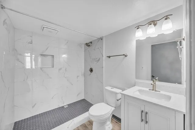 a view of empty room with wooden floor and ceiling fan