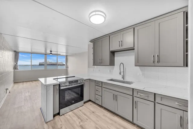 a kitchen with cabinets stainless steel appliances and sink