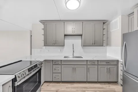 a kitchen with stainless steel appliances granite countertop a stove a sink and a refrigerator