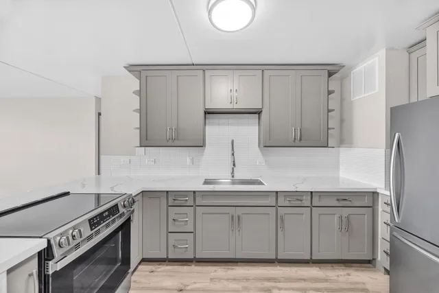 a kitchen with stainless steel appliances granite countertop a stove a sink and a refrigerator