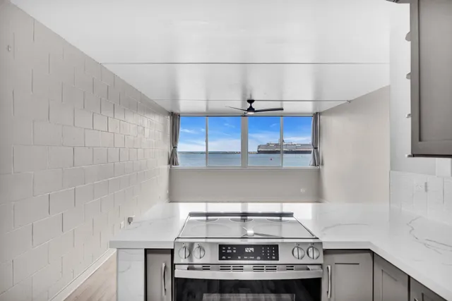 a view of a kitchen with a sink and dishwasher with wooden floor