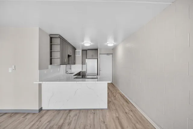 a view of a room with wooden floor and brick walls