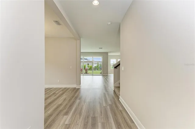 a view of a hallway with wooden floor