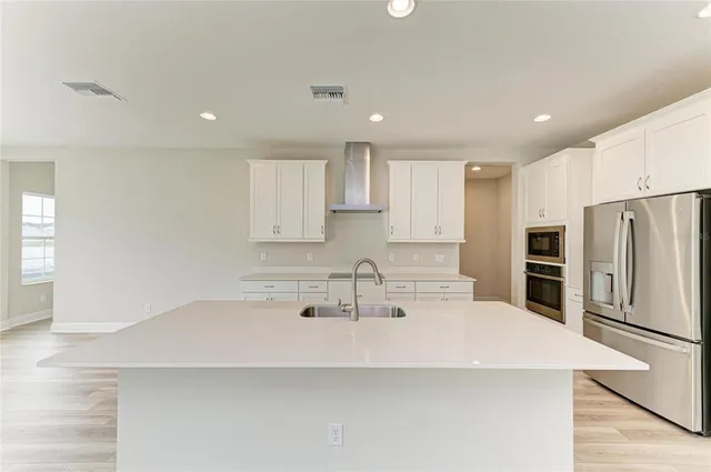 a kitchen with kitchen island a sink stainless steel appliances and cabinets