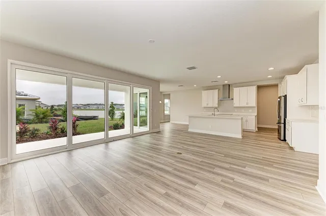 a view of a kitchen with wooden floor and a large window