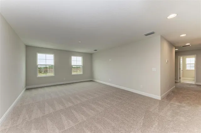 a view of an empty room with window and closet area