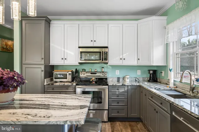 a kitchen with granite countertop a stove top oven microwave and cabinets