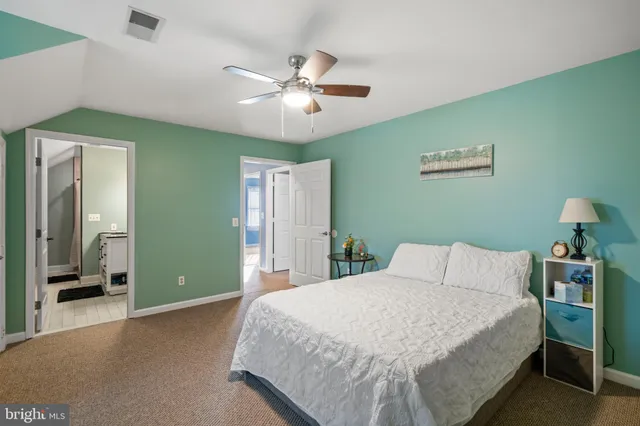 a bedroom with a large bed and a chandelier