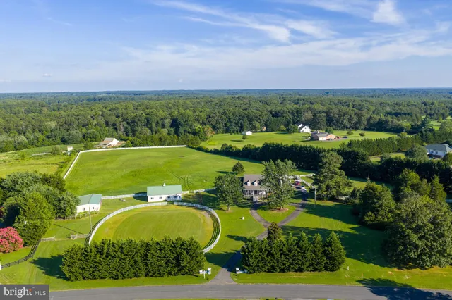 an aerial view of a houses with a garden and lake view