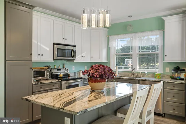 a kitchen with granite countertop a sink stove and cabinets