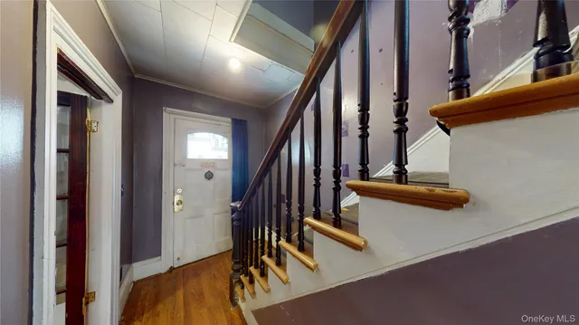 a view of stairs and an empty room with wooden floor
