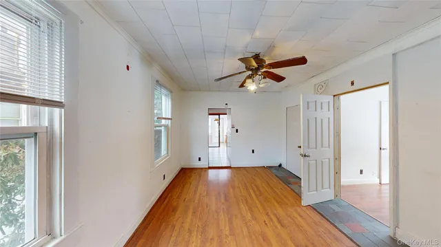 a view of room with window ceiling fan and hardwood floor
