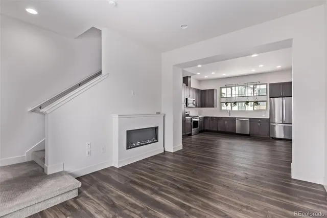 a view of a livingroom with wooden floor and a fireplace