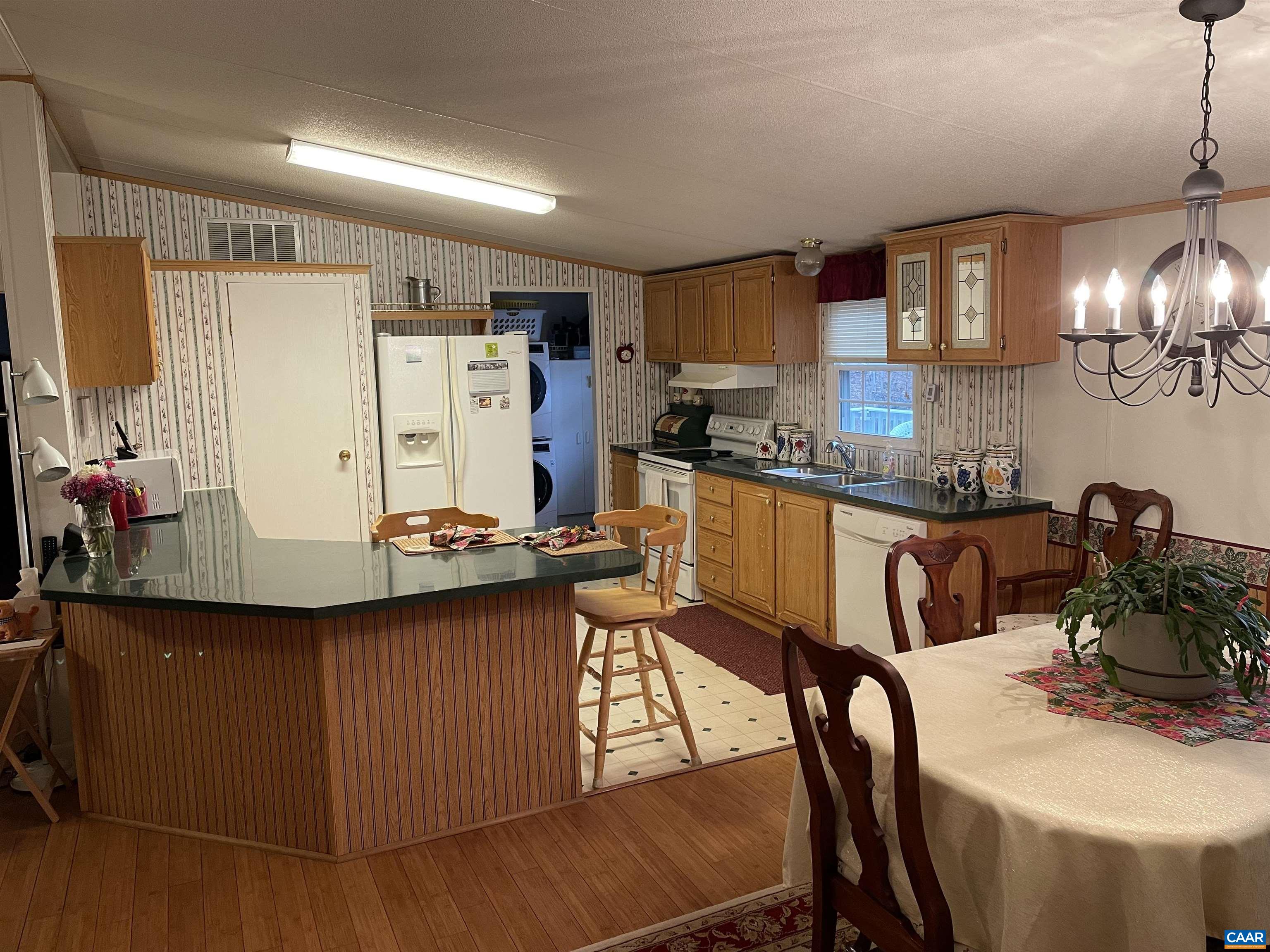2925 Cloverdale Road Bremo Bluff, VA 23022 - Photo 8 of 23 a kitchen with stainless steel appliances granite countertop a stove refrigerator a sink dishwasher and a dining table with wooden floor